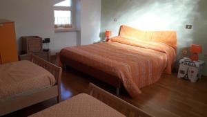 una camera da letto con un letto grande con una coperta arancione di Casa vacanze Il Castagno a Carbognano