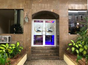 drzwi wejściowe budynku ze schodami i roślinami w obiekcie Hotel Praia Grande Niterói w mieście Niterói