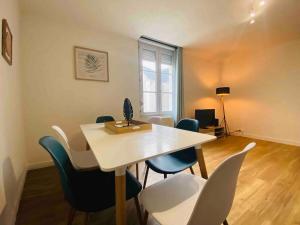 comedor con mesa blanca y sillas en Casa Balzac – T3, en Angers