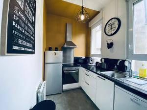een keuken met een koelkast en een wastafel bij Casa Balzac – T3 in Angers