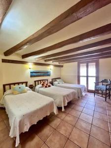 a bedroom with two beds in a room with a ceiling at CAL JOAN pallars in Salás de Pallás