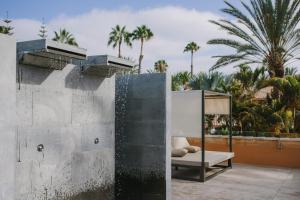 una cama en el lateral de un edificio con palmeras en Maspalomas Resort by Dunas en Maspalomas