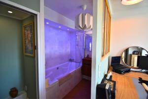 un baño con bañera y espejo en Le Belvédère Parisien, en Aubervilliers 21 fotos más