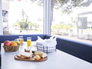 una mesa con una bandeja de pan y fruta. en Tiercé Hotel, en Cagnes-sur-Mer