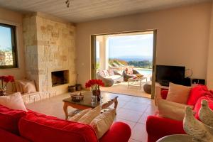 a living room with red furniture and a fireplace at Villa Corali Ideales Resort in Kefallonia
