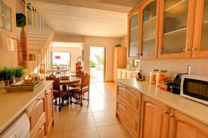 a kitchen with wooden cabinets and a dining room at Villa Corali Ideales Resort in Kefallonia