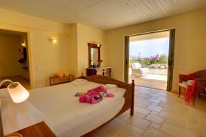 ein Schlafzimmer mit einem Bett mit rosa Blumen darauf in der Unterkunft Villa Litorina Ideales Resort in Kefalonia