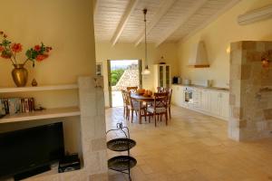 eine Küche und ein Esszimmer mit einem Tisch und einem TV in der Unterkunft Villa Litorina Ideales Resort in Kefalonia