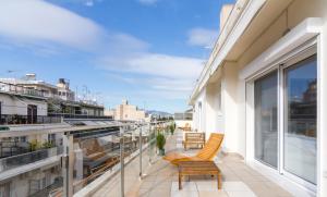 a balcony with chairs and windows on a building at Luxurious Apt For 6 Ppl Near The Center of Athens in Athens