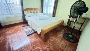 een slaapkamer met een bed en een ventilator bij The Corner House in Tortuguero