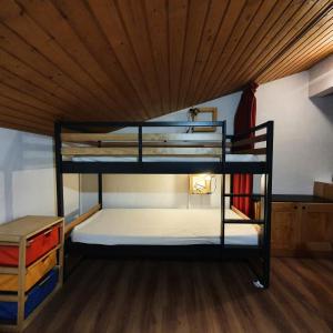 two bunk beds in a room with a wooden ceiling at Résidence Les Avenieres - 3 Pièces pour 8 Personnes 144 in Villarodin-Bourget