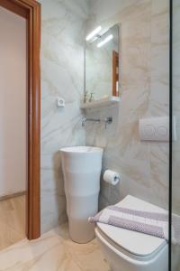 Baño blanco con aseo y lavamanos en Luxurious Apt For 6 Ppl Near The Center of Athens, en Atenas