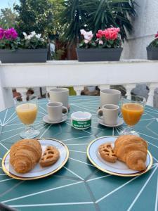 a table with two plates of croissants and orange juice at VesuvioSerenity- B&B with Breakfast & Free Parking in Ercolano