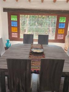 une table à manger avec des chaises et une grande fenêtre dans l'établissement Spain style country house in Cajica, à Cajicá