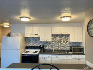 a kitchen with white cabinets and a clock on the wall at Halibut House Unit 2 in Seward