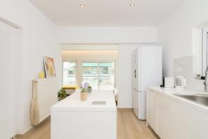 a kitchen with white counters and a white refrigerator at Luxurious Apt For 6 Ppl Near The Center of Athens in Athens