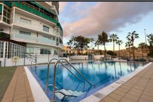 a swimming pool in front of a building at Penthouse Apartment Las Americas in Playa de las Americas