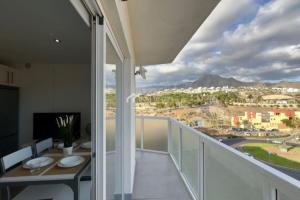 a balcony with a table and a view of a city at Penthouse Apartment Las Americas in Playa de las Americas
