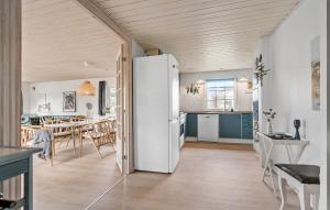 a kitchen and dining room with a white refrigerator at Holiday Home Nørre Nebel 9 in Nymindegab