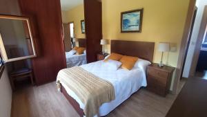a hotel room with a bed and a mirror at Casa Alicia in Poio +19 photos