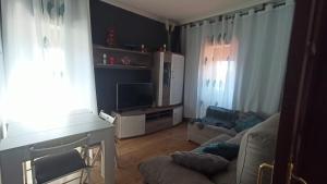 a living room with a couch and a tv at Casa Alicia in Poio