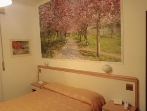 1 dormitorio con una pintura en la pared en Hotel Rosa Meublé, en Porto San Giorgio