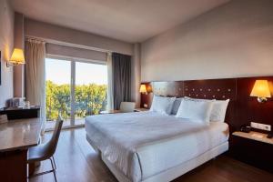 a hotel room with a large bed and a window at Silken Turcosa in Castellón de la Plana