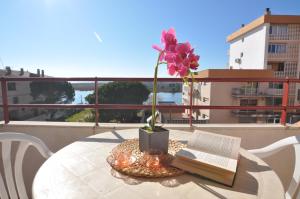 ロザスにあるRNET - IR 1-48 - Studios Roses Costa Bravaのバルコニーに花のテーブルと本