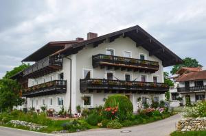 a white building with balconies and flowers at Gästehaus Nigglhof in Rimsting