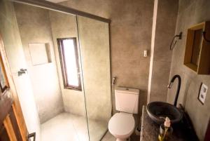 a bathroom with a shower with a toilet and a sink at Daya Ma Hospedagem in Alto Paraíso de Goiás