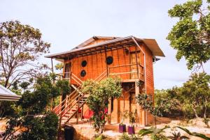ein aus Holz gebautes Haus mit einer Treppe in der Unterkunft Daya Ma Hospedagem in Alto Paraíso de Goiás