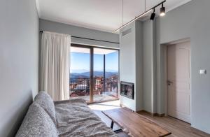 a living room with a couch and a large window at Arachova's Experience S2 in Arachova
