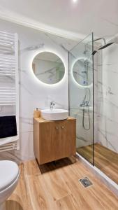 a bathroom with a sink and a toilet and two mirrors at Arachova's Experience S2 in Arachova