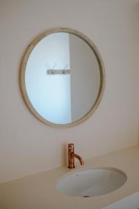 a bathroom sink with a mirror on the wall at Adagio House in Valdamonte