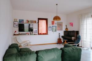 sala de estar con sofá verde y TV en Adagio House, en Valdamonte