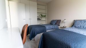 um quarto com 2 camas, uma cadeira e uma mesa em Spacious 68m2 apartment with fabulous forest view em Järvenpää