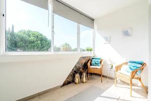 uma sala de estar com duas cadeiras e uma grande janela em Spacious 1 bed in Vilamoura, Fast Wifi & Pool em Quarteira