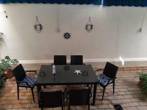una mesa negra con sillas y relojes en la pared en 2 bedrooms apartement at Cadiz 450 m away from the beach with furnished terrace and wifi, en Cádiz