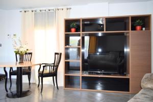 a living room with a entertainment center with a television at Alojamientos Yecla Centro by Casa de la Feria del Mueble Yecla in Yecla
