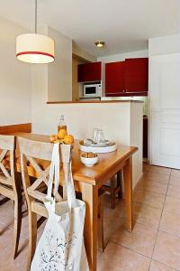 een keuken met een houten tafel met fruit erop bij La résidence du Lac - maeva Home - Appartement 2 pièces 5 personnes - Conf 694 in Monflanquin
