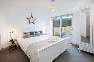 a white bedroom with a bed and a large window at 3 Bed in Belford oc-cn065 in Belford