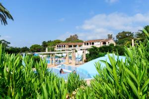 uma piscina num resort com pessoas a nadar nela em Résidence Les Parcs de Grimaud - maeva Home - Appartement 3 pièces 6 perso 804 em Grimaud