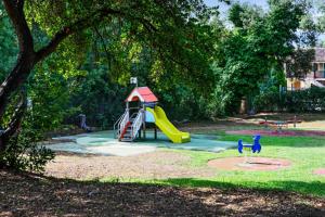 um parque infantil com escorrega num parque em Résidence Les Parcs de Grimaud - maeva Home - Appartement 3 pièces 6 perso 804 em Grimaud