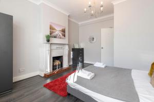 a white room with a bed and a fireplace at Chrystal Palace Stays with free parking Lambeth in Upper Norwood