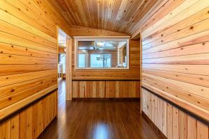 una sauna con paredes de madera y una ventana en ログコテージ風の丘 en Topetsu