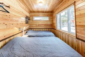 Topetsuにあるログコテージ風の丘の木造キャビン内のベッドルーム1室(ベッド2台付)