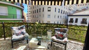 einen Balkon mit einem Glastisch und 2 Stühlen in der Unterkunft Terrasa de Mercado Central in Valencia