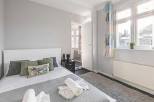 a white bedroom with a bed and a window at Chrystal Palace Stays with free parking Lambeth in Upper Norwood