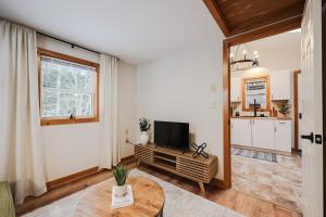 a living room with a television and a table at EverHaus Cabin by the Brook - Harvard Brook Cabins in Lincoln