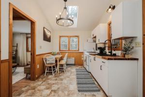 a kitchen with a table and a white refrigerator at EverHaus Cabin by the Brook - Harvard Brook Cabins in Lincoln